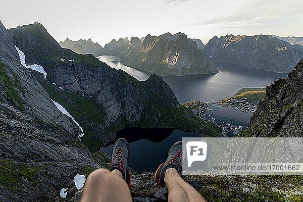 Wanderer sitzt auf dem Berg bei Reinebringen  Lofoten  Norwegen