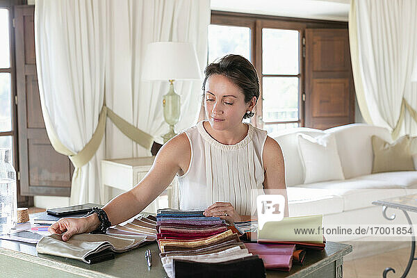 Female wedding planner choosing fabric swatches while working at home