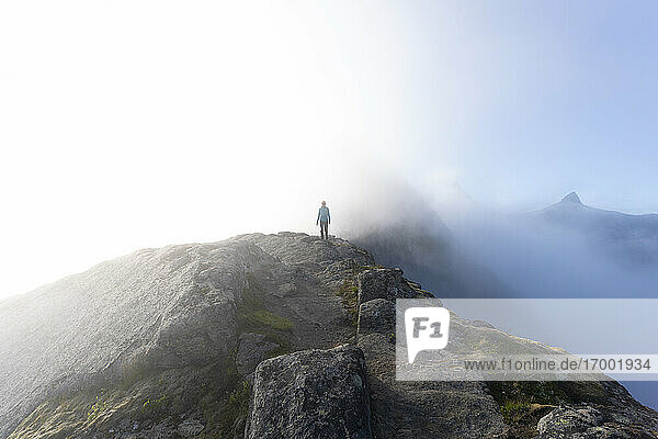 Hiker standing on mountain at Helvetestinden  Lofoten  Norway