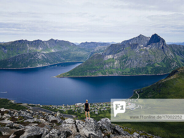 Hiker looking at view while standing on mountain at Segla  Norway