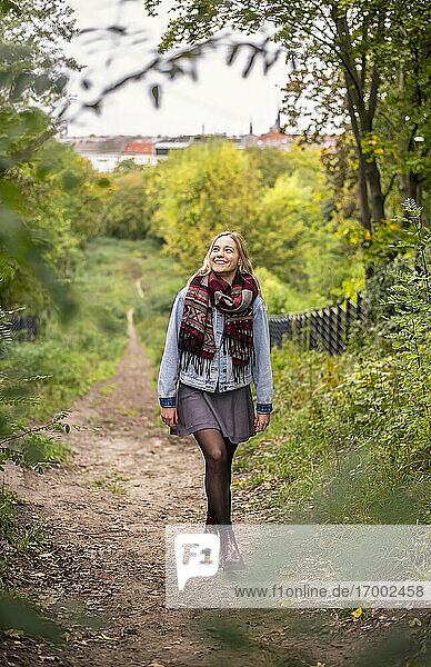 Junge Frau geht im Herbst im Park spazieren
