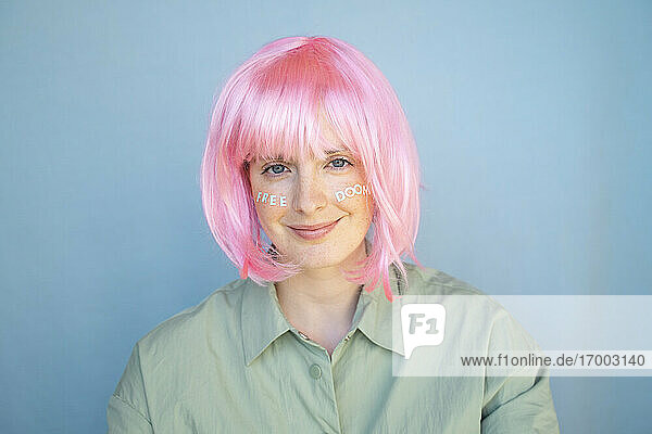 Junge Frau mit rosa Perücke  Buchstaben im Gesicht  freier Untergang