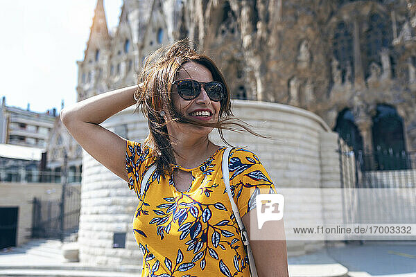 Mid adult woman smiling while standing against Sagrada Familia at Barcelona  Catalonia  Spain