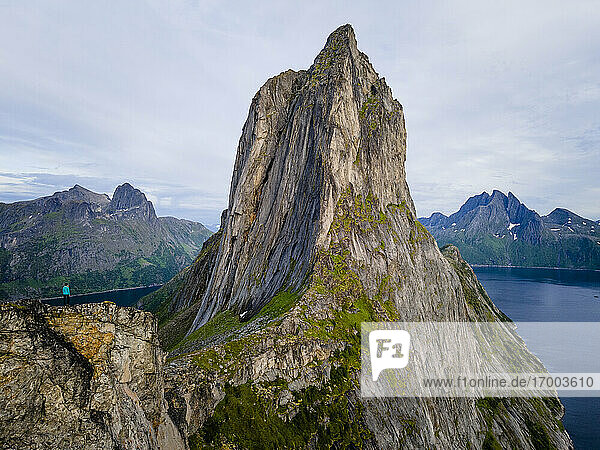 Stehende Frau  die die Aussicht auf den Berg Segla in Norwegen bewundert