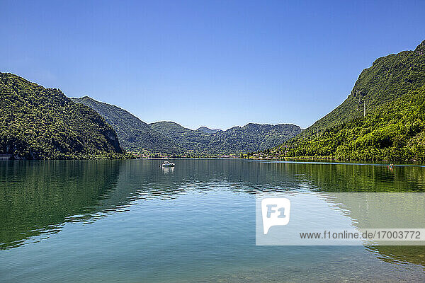Idyllic view of Lake Idro and mountain against blue sky