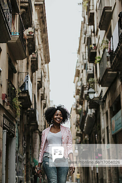 Lächelnde nachdenkliche Frau beim Spaziergang in der Stadt