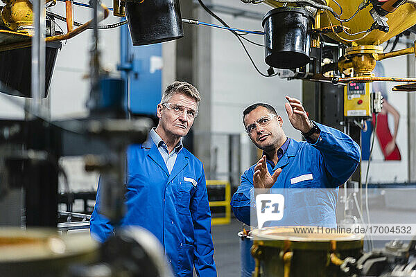 Technicians planning about machinery while working in industry