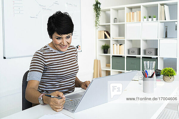 Porträt einer Geschäftsfrau bei der Arbeit im Büro vor einem Laptop