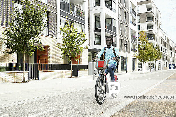 Mature male commuter riding bicycle on street in city