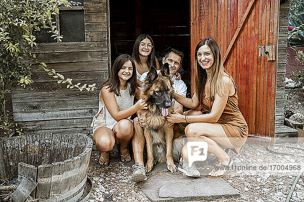 Lächelnde Familie mit Hund im Hinterhof