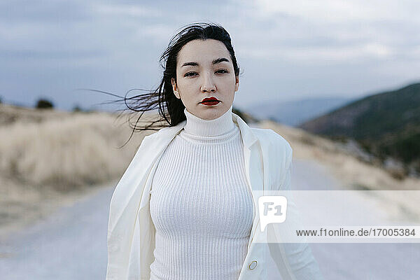 Junge Frau in weißen Jacken steht auf der Straße