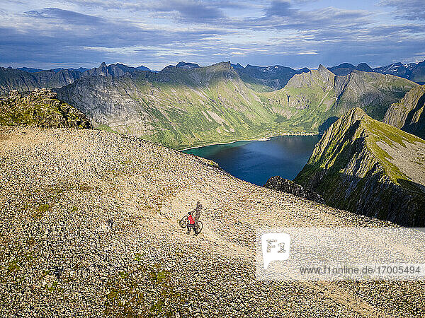 Männlicher Forscher mit Fahrrad auf einem Berg am Husfjellet  Senja  Norwegen