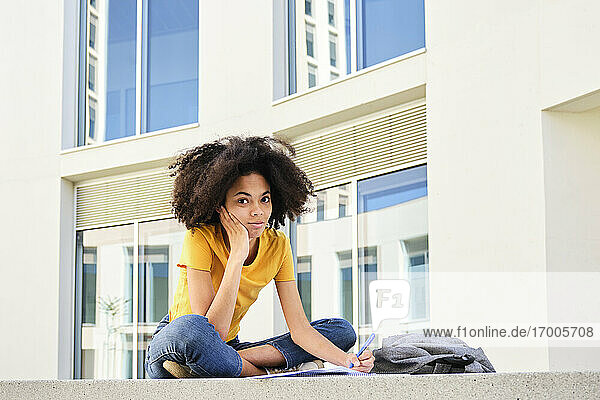 Studentin studiert sitzend auf dem Universitätscampus