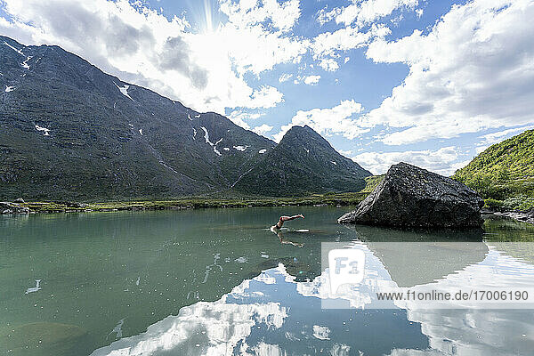 Woman jumping in river at Knutshoe  Norway