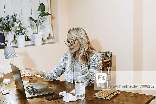 Ältere Frau im Gespräch per Videoanruf während einer Online-Beratung zu Hause