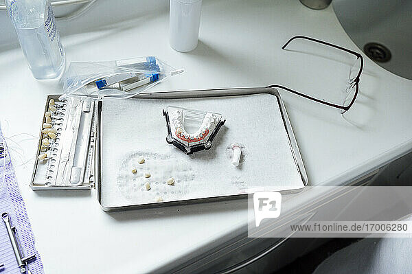 Zahnersatz auf einem Tablett mit medizinischen Geräten auf einem Tisch in einer Klinik