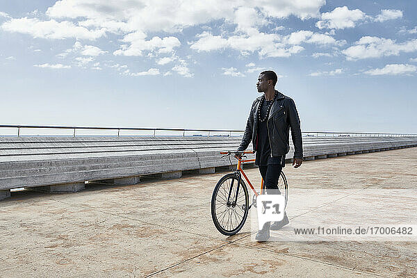 Man with bike on waterfront promenade