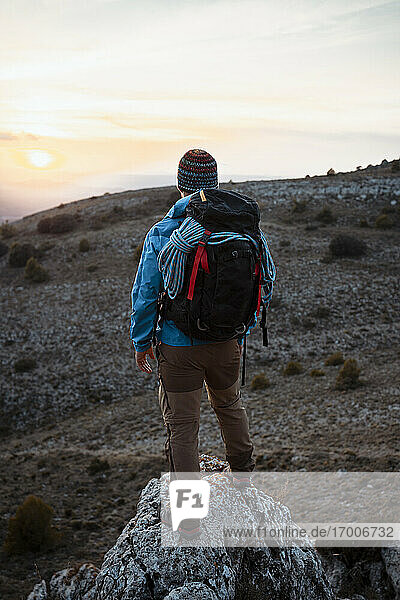 Männlicher Wanderer betrachtet die Aussicht vom Felsenberg bei Sonnenuntergang