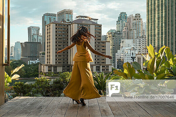 Rückansicht einer tanzenden Frau auf einer Dachterrasse  Bangkok  Thailand