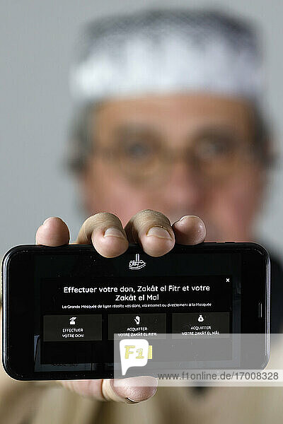 Close-up on a smartphone. Zakat (alms) is the third pillar of Islam. France.