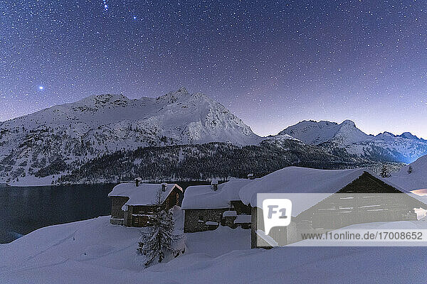Sternenhimmel über dem Gipfel des Piz Da La Margna und den schneebedeckten Spluga-Hütten  Maloja  Engadin  Kanton Graubünden  Schweiz  Europa