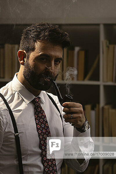 Portrait of bearded man smoking pipe 
