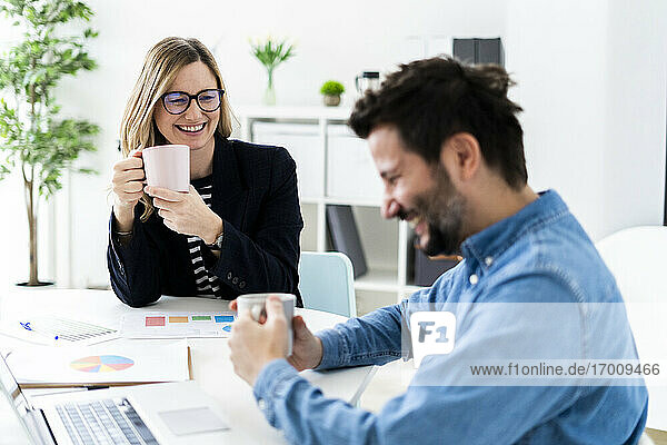 Lächelnde Geschäftsleute im Gespräch im Büro