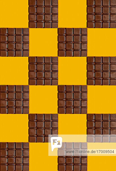 Muster von Schokoladentafeln auf gelbem Hintergrund