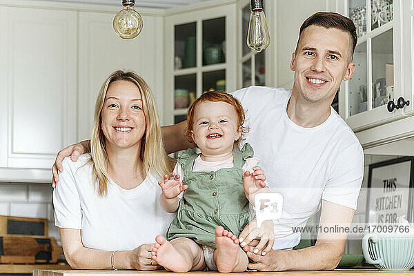 Porträt einer glücklichen Familie mit kleiner Tochter zu Hause