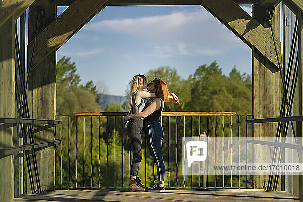 Paar küsst auf einer Brücke stehend