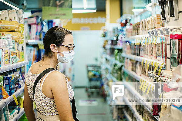 Mittlere erwachsene Frau mit Gesichtsschutzmaske im Supermarkt