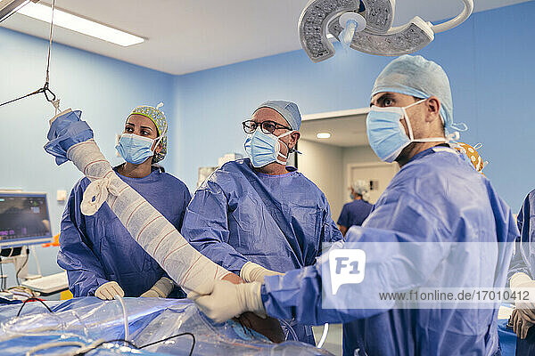 Ärzte mit Gesichtsschutzmaske bei einer Operation im Operationssaal