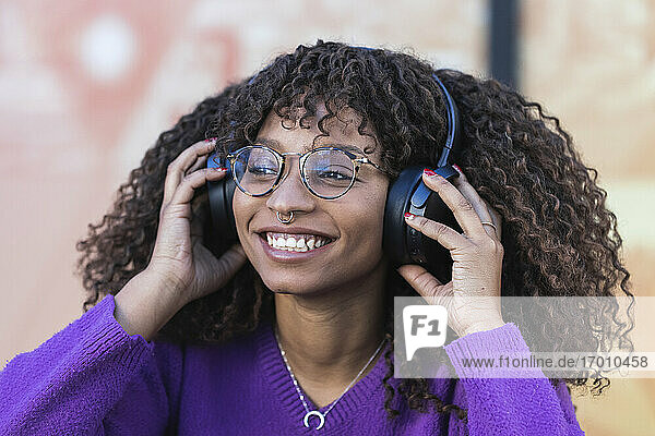 Lächelnde Frau genießt Musik über Kopfhörer