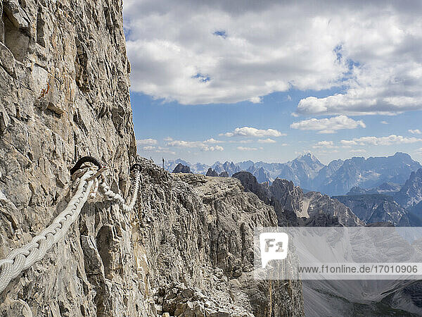 Rope hanging from steep cliff in Sexten Dolomites