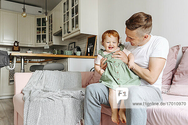 Father and baby daughter on sofa