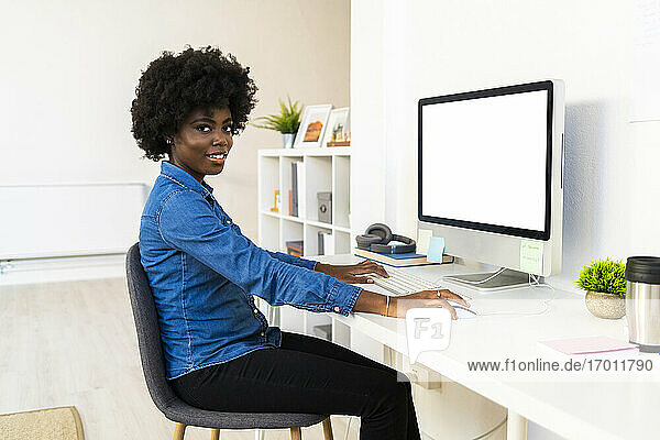 Young woman working on computer while sitting at home