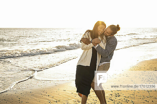 Fröhliches Paar am Strand an einem sonnigen Tag
