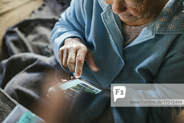 Ältere Frau  die zu Hause eine Textnachricht auf ihrem Smartphone schreibt