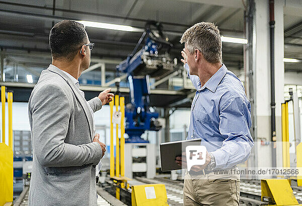 Manager und Vorgesetzter diskutieren über Maschinen in der Fabrik