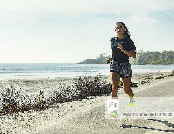 USA  California  Dana Point  Woman running on road by coastline