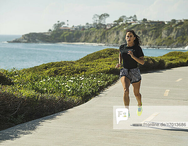 USA  Kalifornien  Dana Point  Frau läuft auf der Straße an der Küste