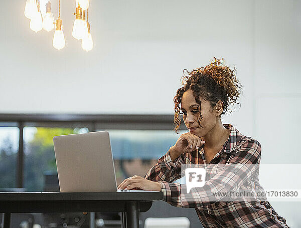 Frau sitzt mit Laptop im Büro