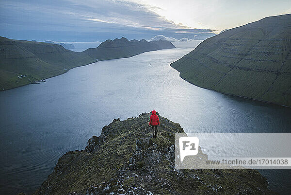 Denmark  Faroe Islands  Klaksvik  Woman standing on Klakkur mountain and looking at fjord