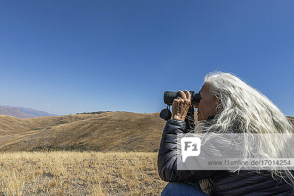 USA  Idaho  Bellevue  Frau schaut durch Fernglas in Wüste