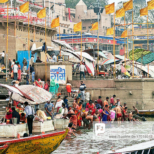 Varanasi (ex-Bénares)  Uttar Pradesh  Indien . Jeden Tag bei Sonnenaufgang und im Laufe des Vormittags trifft sich eine Schar von Männern und Frauen am Rande des heiligen Flusses Ganges  um vor der Sonne die Waschungen vorzunehmen. Während die Männer sich ausziehen und mit einem einfachen Lendenschurz ins Wasser tauchen  zögern die Frauen nicht  sich bekleidet ins Wasser zu stürzen.