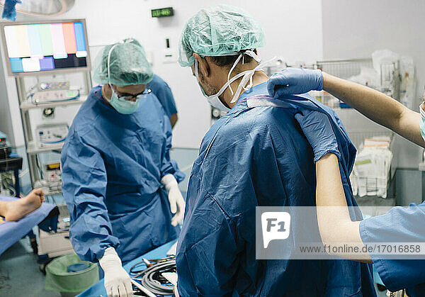 Eine Ärztin hilft einem orthopädischen Chirurgen im Operationssaal eines Krankenhauses