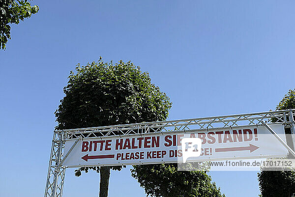 Soziales Distanzierungsbanner vor strahlend blauem Himmel während der COVID-19