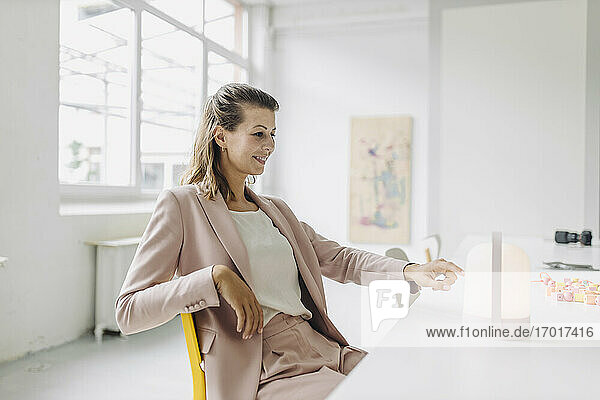Lächelnde Geschäftsfrau mit Blick auf die Laterne im Büro