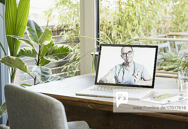 Männlicher Arzt gibt Ratschläge per Videoanruf auf dem Laptop zu Hause