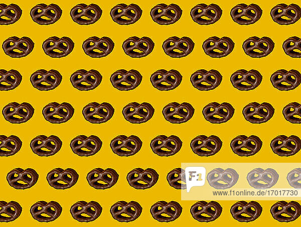 Muster von Schokoladenbrezeln auf gelbem Hintergrund